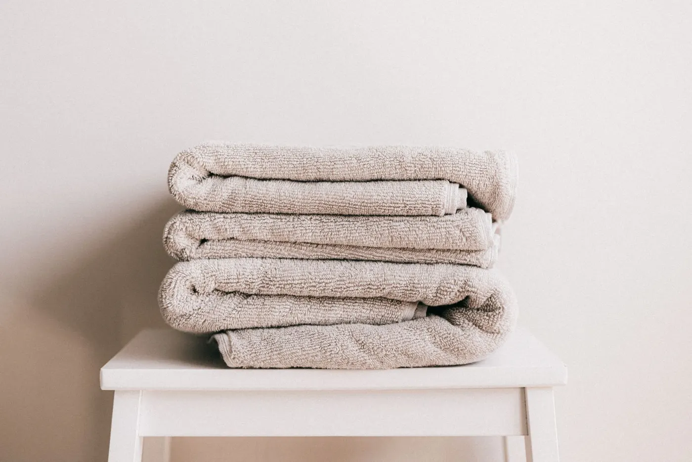 Neatly folded fresh towels on a white stool